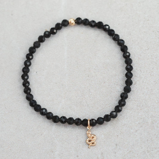Obsidian snake bracelet crafted with 14K gold from Earthly Abundance, featuring a detailed snake design on a sleek black obsidian band.