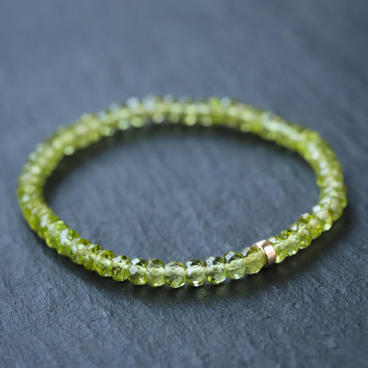 Peridot bracelet with 14K gold setting from Earthly Abundance, featuring vibrant green gemstones on a delicate chain.