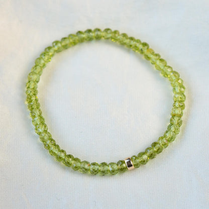 Peridot bracelet with 14K gold setting from Earthly Abundance, featuring vibrant green gemstones on a delicate chain.