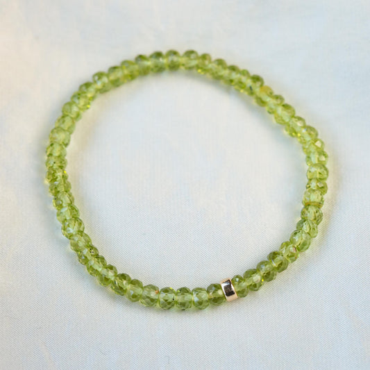 Peridot bracelet with 14K gold setting from Earthly Abundance, featuring vibrant green gemstones on a delicate chain.