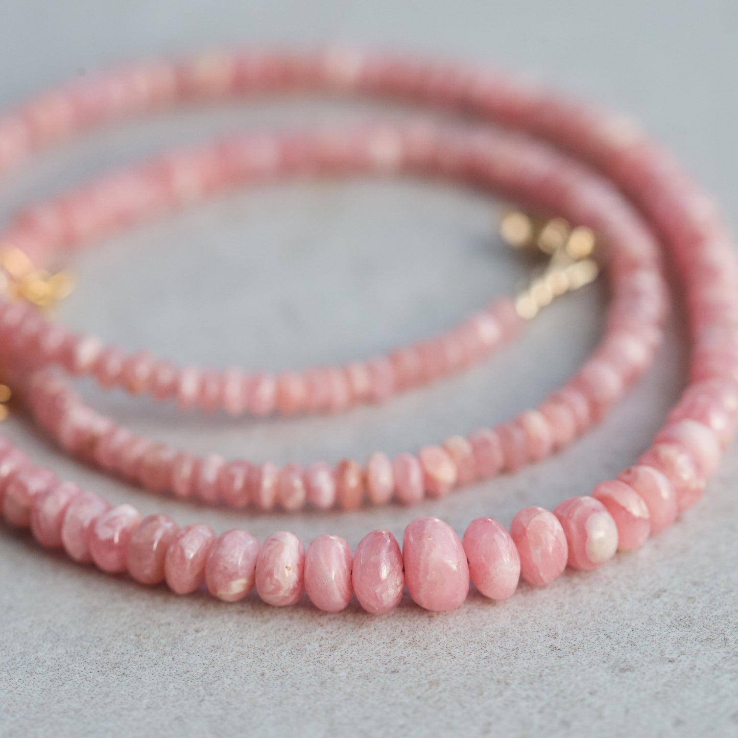 Earthly Abundance Rhodochrosite necklace featuring polished pink and red gemstone beads on a delicate chain.