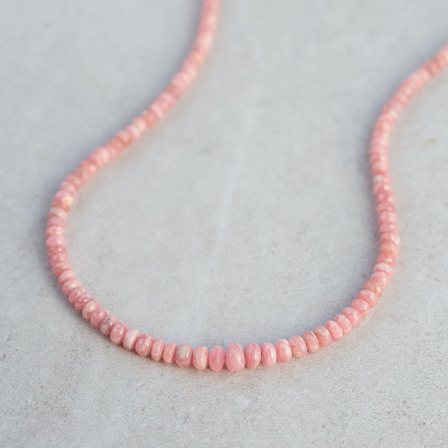 Earthly Abundance Rhodochrosite necklace featuring polished pink stones on a delicate silver chain.