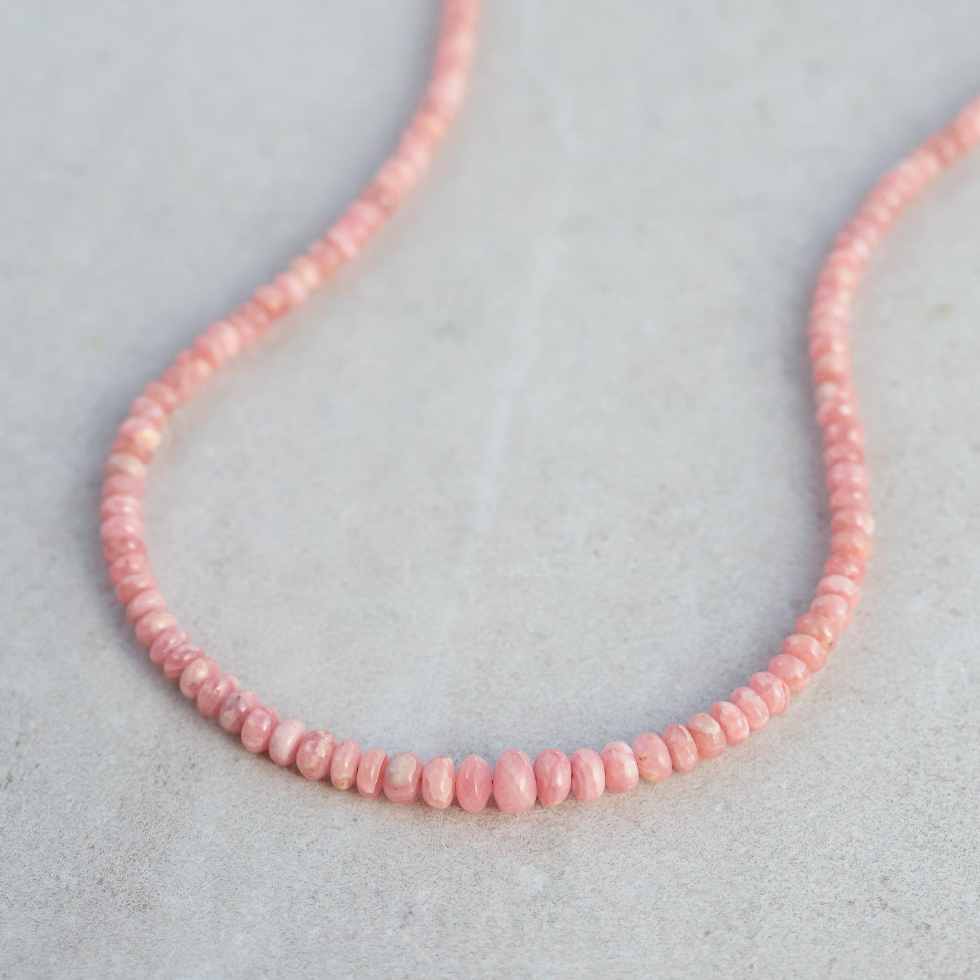 Earthly Abundance Rhodochrosite necklace featuring polished pink stones on a delicate silver chain.