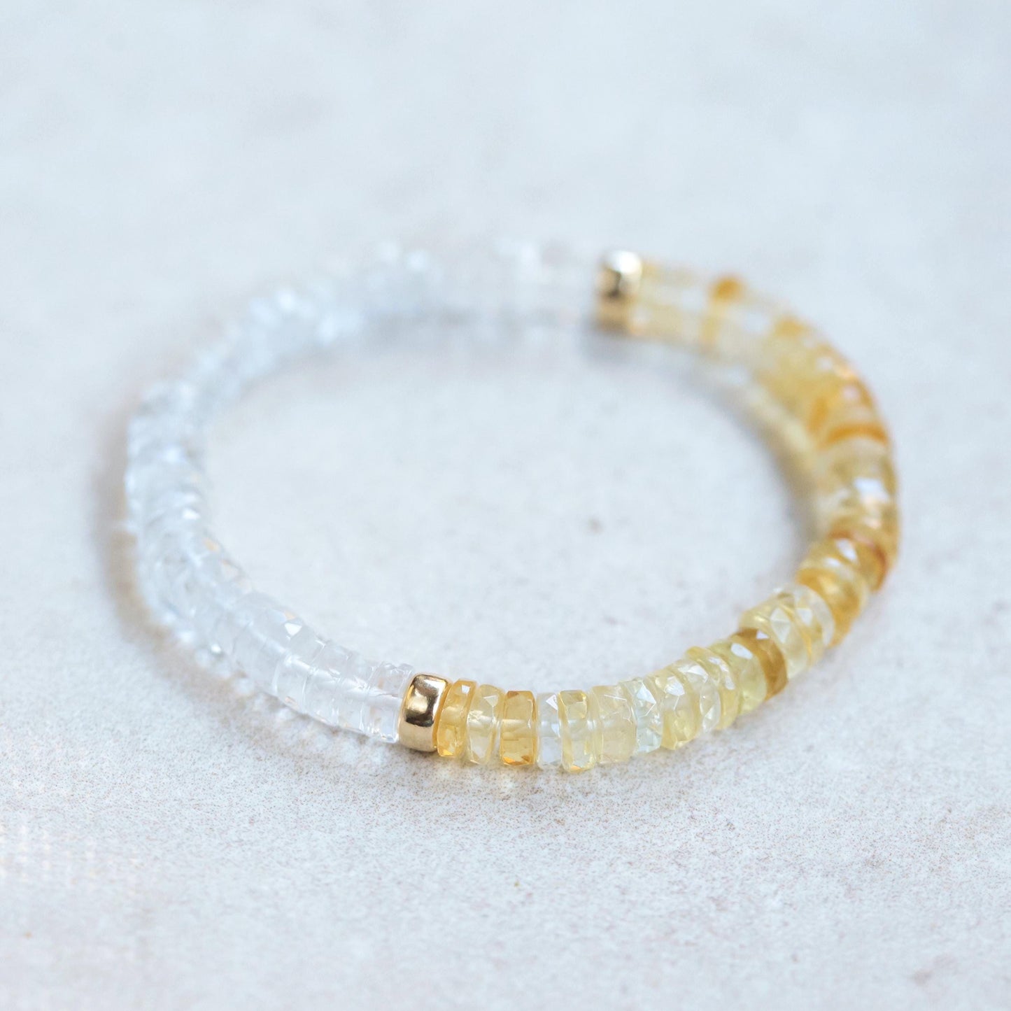 Citrine and clear quartz crystals from Earthly Abundance, showcasing bright orange and transparent gemstones on a neutral background.
