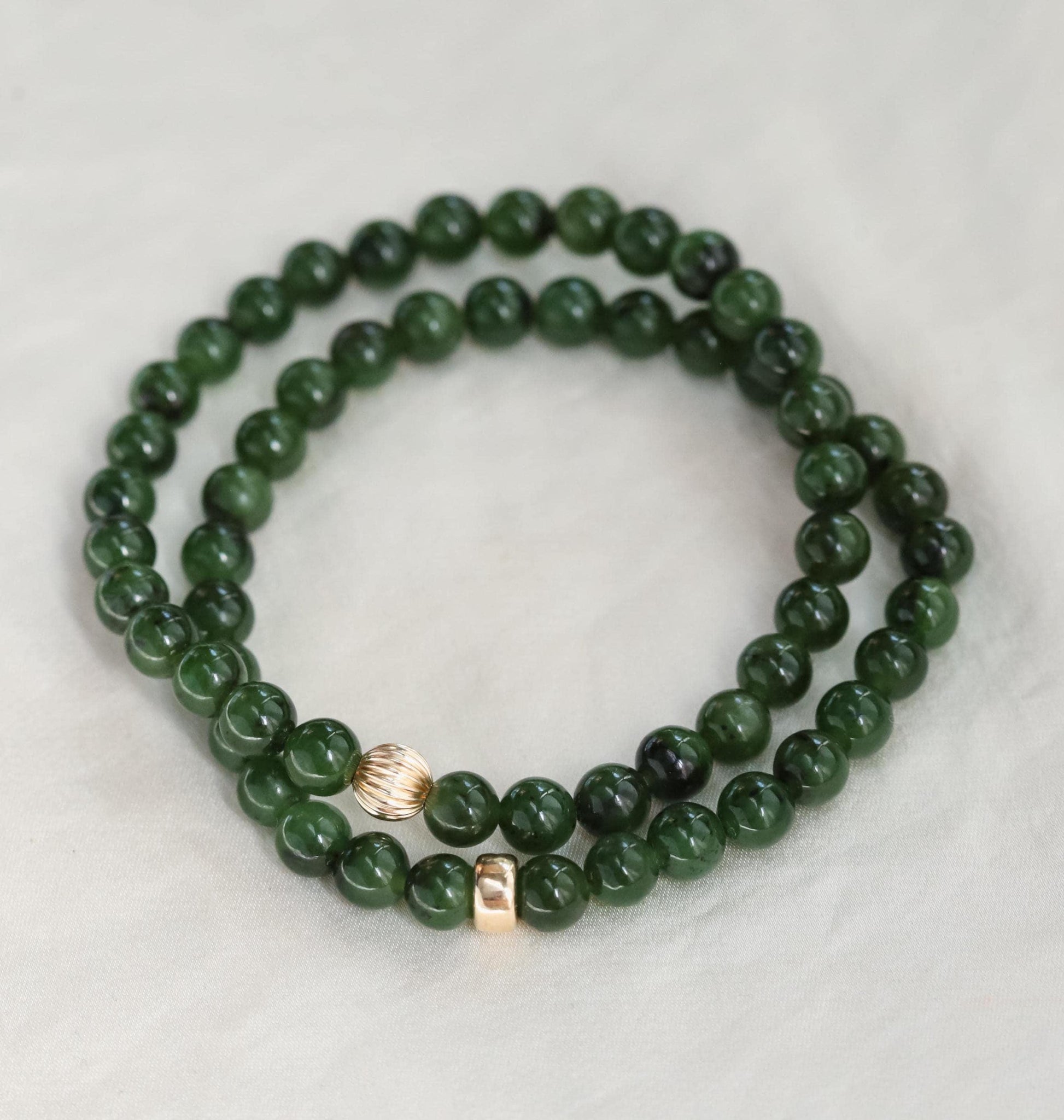 Smooth 6mm Canadian Jade beads from Earthly Abundance, showcasing their vibrant green color and polished surface.