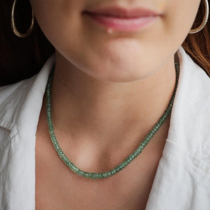 Green Kyanite necklace with polished gemstone pendant on a silver chain, displayed against a neutral background.