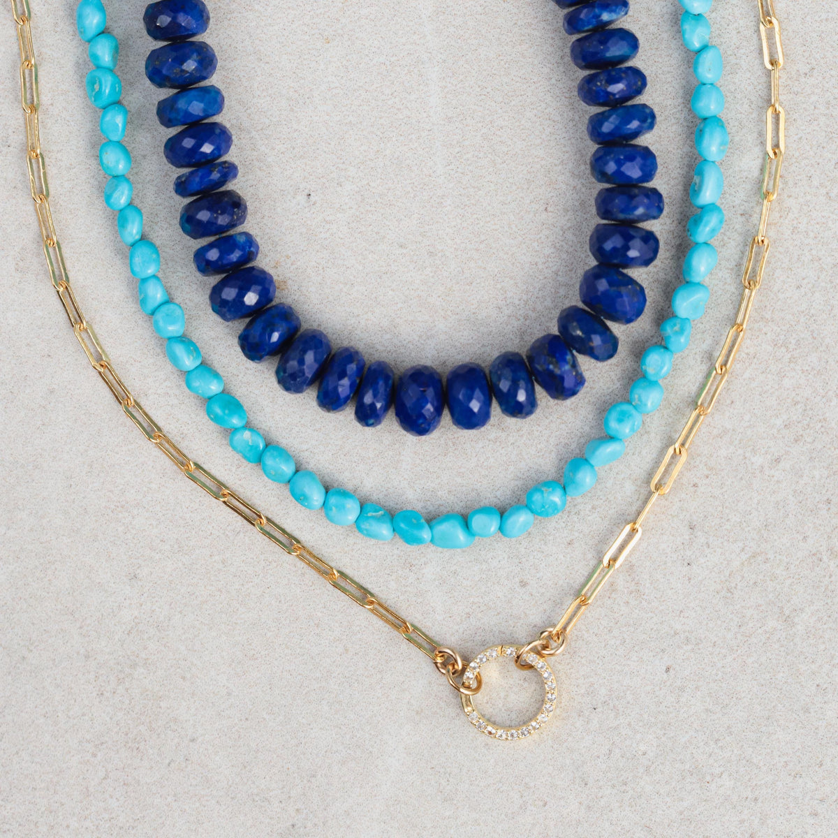 Lapis lazuli faceted rondel necklace by Earthly Abundance featuring deep blue stones with gold-colored accents on a chain.