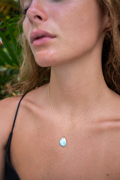 Larimar pendant in 14K gold with a polished blue gemstone, crafted by Earthly Abundance, featuring a delicate chain.