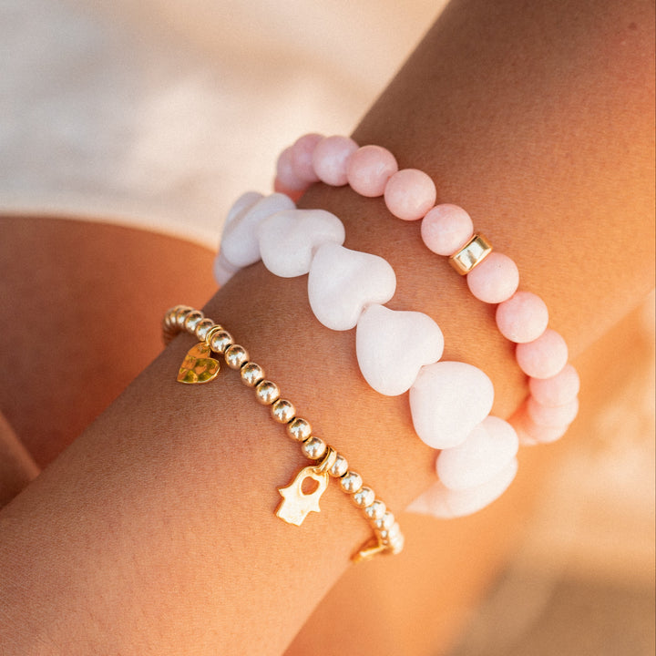 Pink mango calcite bracelet with heart-shaped beads from Earthly Abundance Jewelry, featuring a delicate, natural gemstone design.
