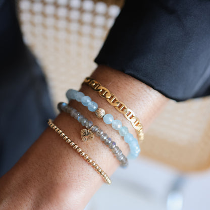 Faceted aquamarine bracelet by Earthly Abundance featuring multiple blue gemstone beads on an elastic cord.