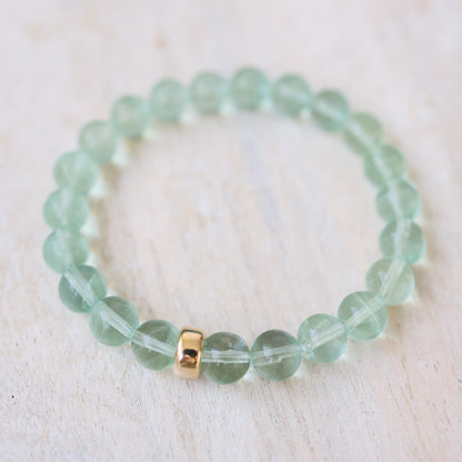 Sea glass green fluorite bracelet by Earthly Abundance featuring smooth, polished fluorite beads on a stretchy cord.