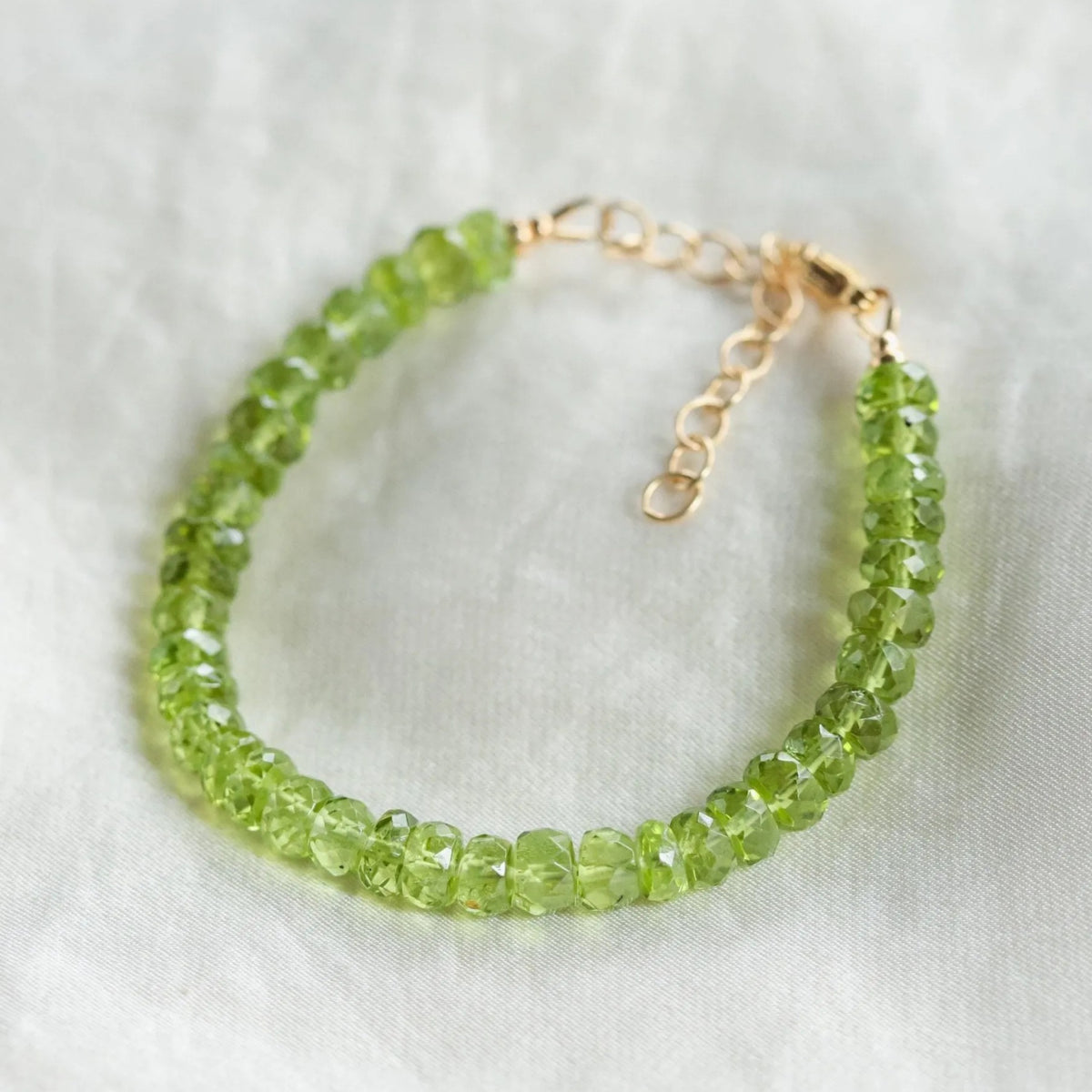 Faceted peridot rondel bracelet by Earthly Abundance featuring vibrant green gemstones on a delicate silver chain.