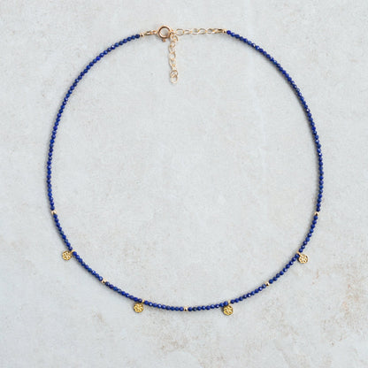 Lapis Daisy Necklace by Earthly Abundance featuring a delicate gold chain with a blue lapis lazuli flower pendant.