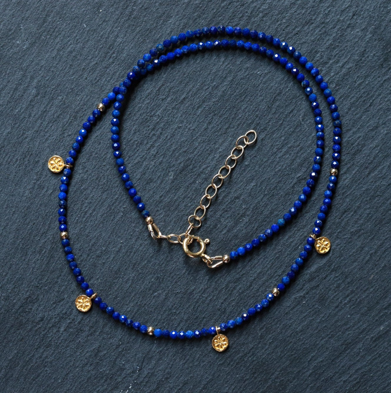 Lapis daisy necklace from Earthly Abundance featuring a delicate pendant with a blue lapis stone and floral design.