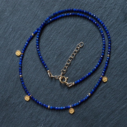 Lapis daisy necklace from Earthly Abundance featuring a delicate pendant with a blue lapis stone and floral design.