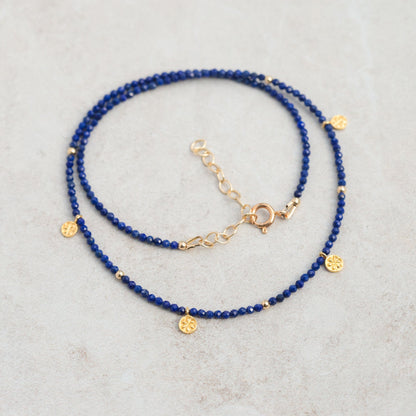 Earthly Abundance lapis daisy necklace featuring a blue lapis lazuli pendant with daisy floral design on a delicate chain