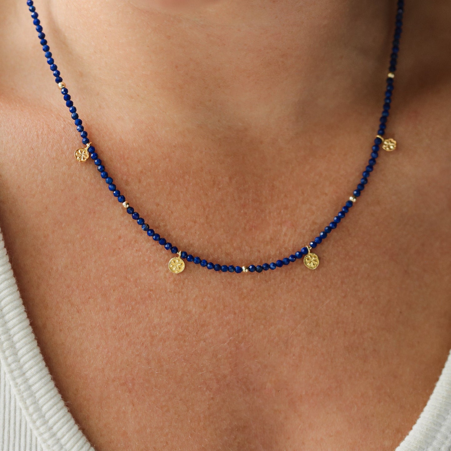 Earthly Abundance lapis daisy necklace featuring a blue lapis gemstone pendant with daisy flower design on a silver chain.