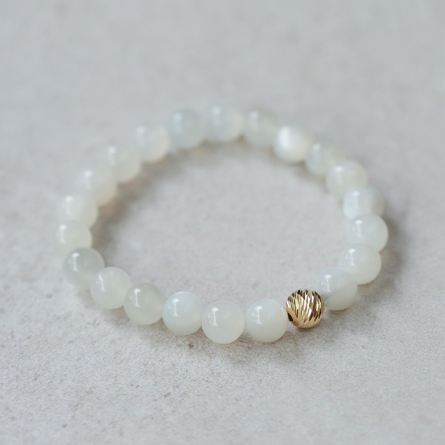 Ethereal Moonstone Bracelet with 14K gold clasp from Earthly Abundance, featuring shimmering moonstone beads on a delicate chain.