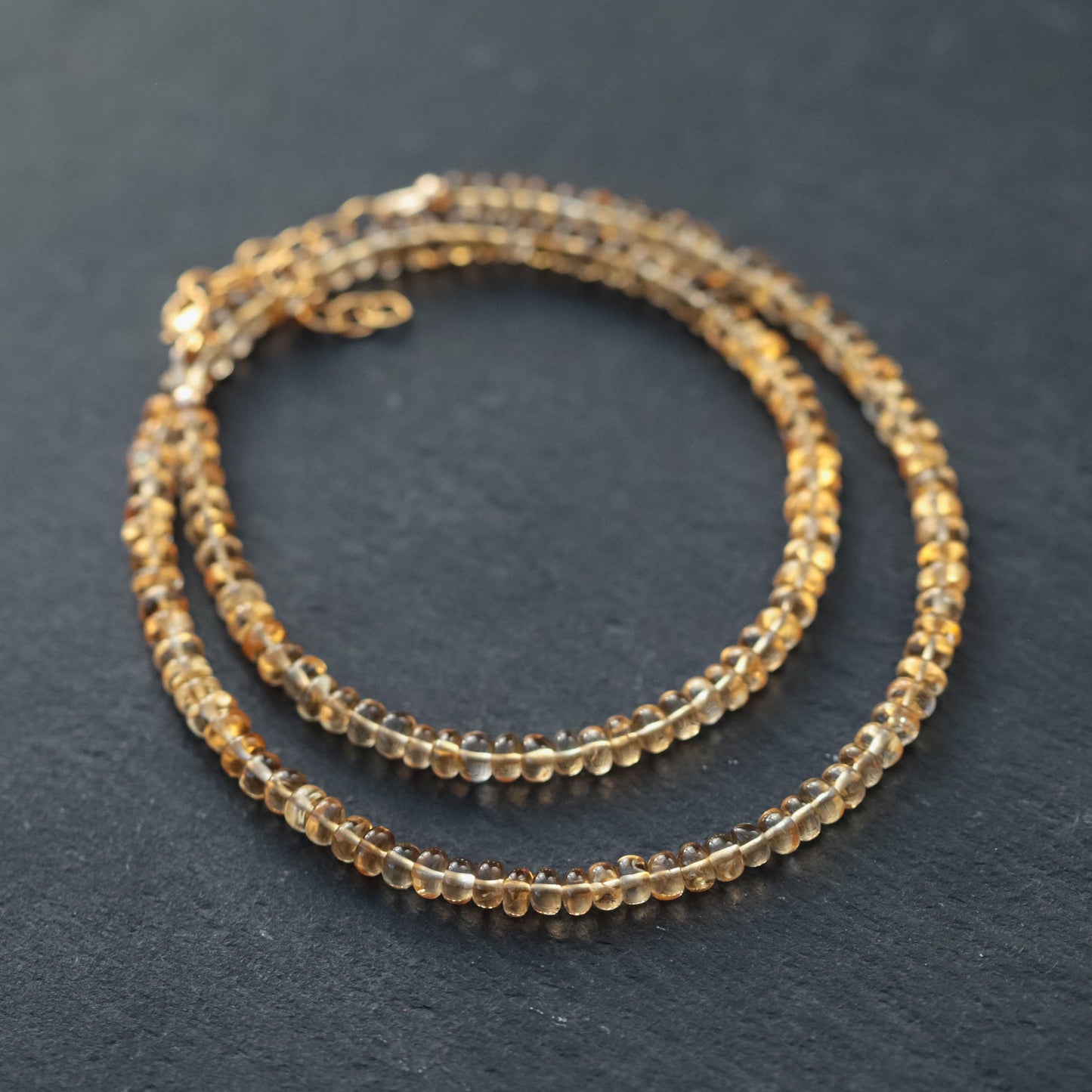 Luminous citrine necklace with a gold chain featuring a large, glowing citrine pendant, styled for elegant wear.