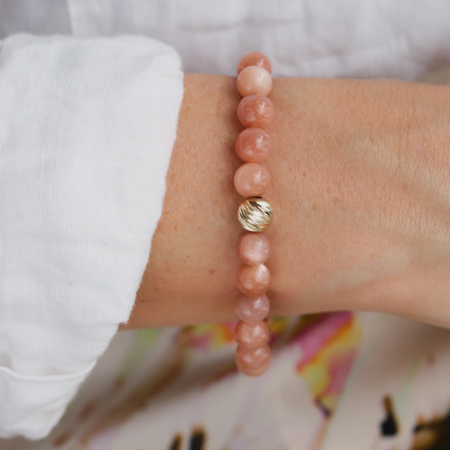 Paloma Peach Moonstone bracelet by Earthly Abundance featuring peach and iridescent moonstone beads on a delicate string.