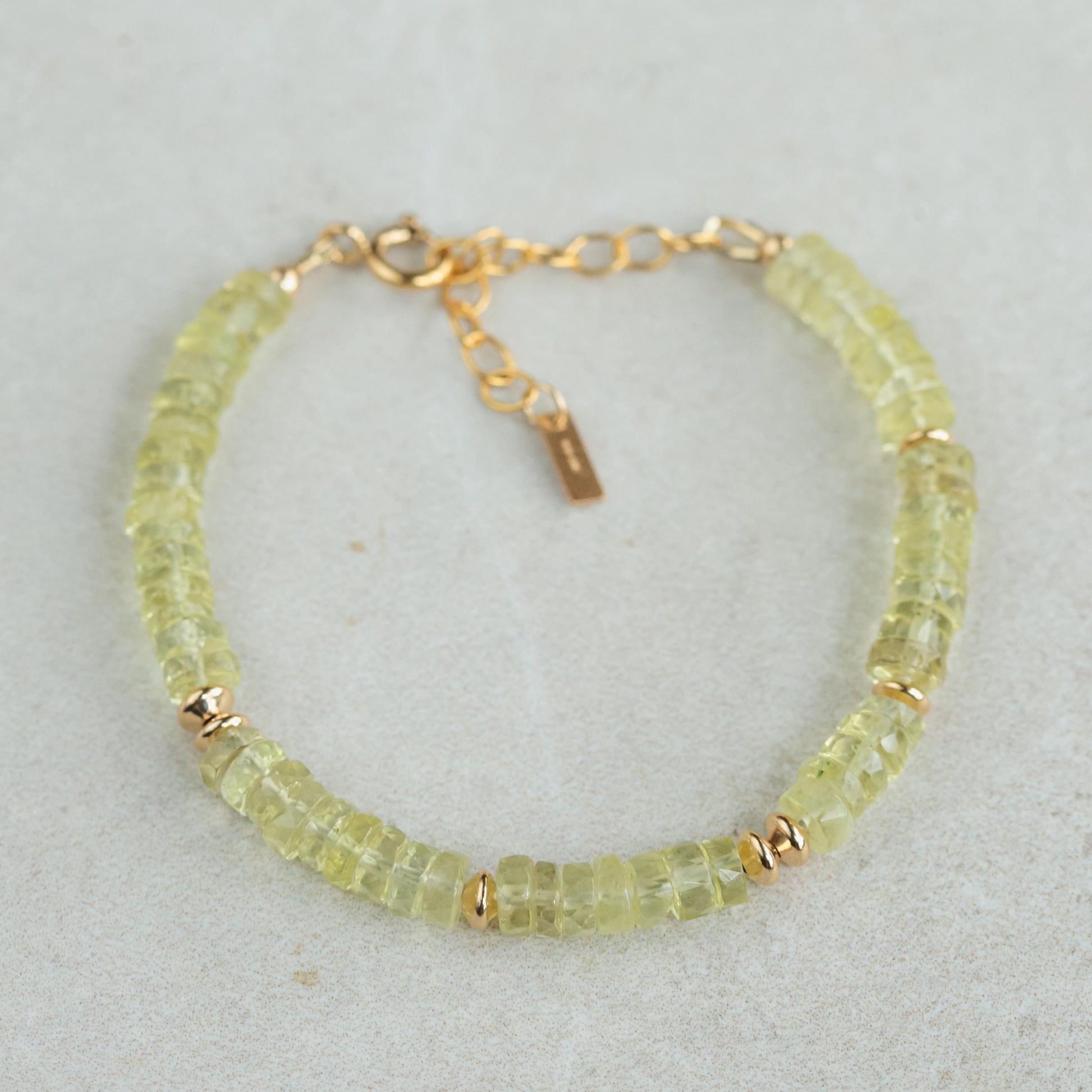 Natural lemon quartz bracelet with smooth yellow stones on an elastic band, showcasing earthy and vibrant gemstone jewelry.