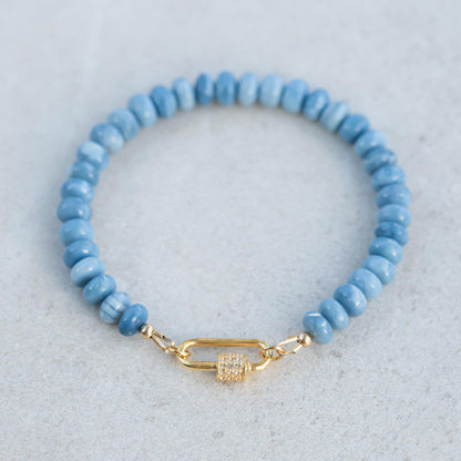 Blue opal topaz bracelet featuring polished gemstone beads on a stretch cord, showcasing vibrant blue and teal hues.