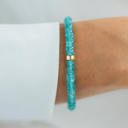 Earthly Abundance apatite heishi bracelet with small blue-green gemstone beads on a white background.