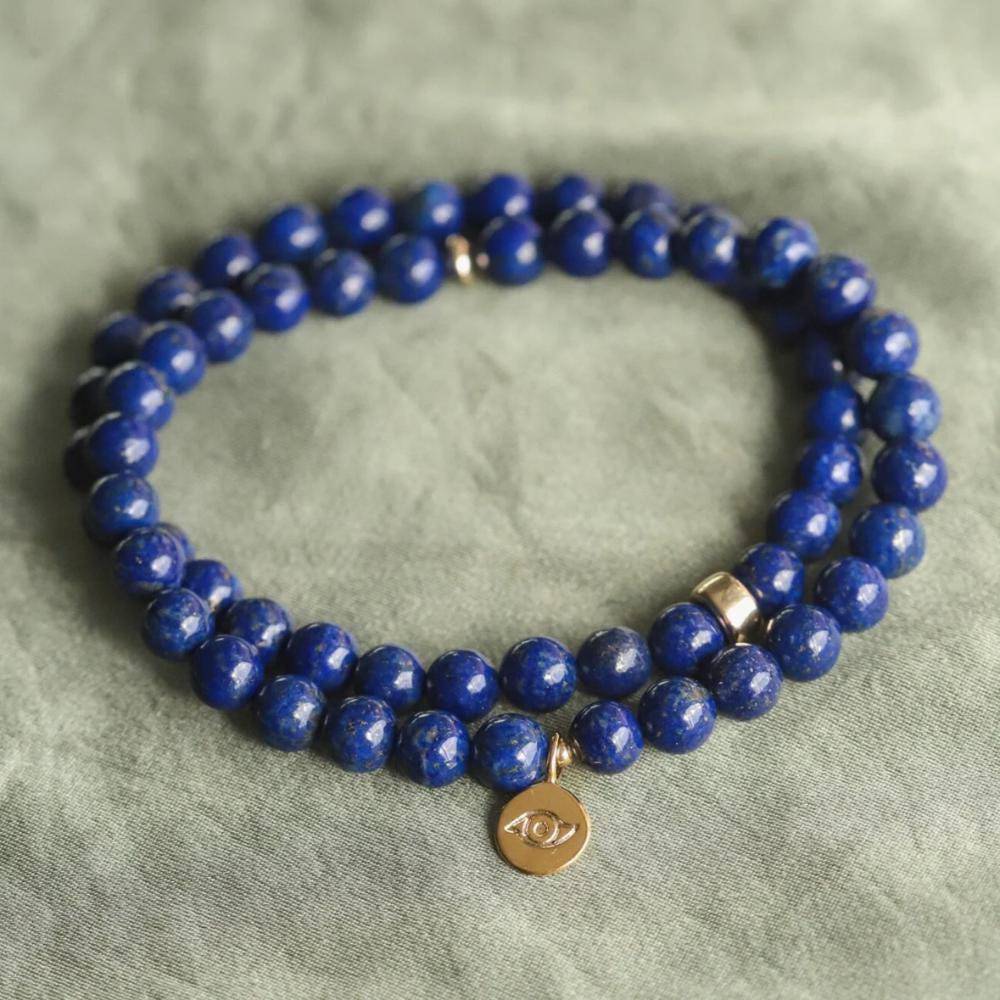Lapis Lazuli bracelet with polished blue stones and gold accents from Earthly Abundance Jewelry displayed on a neutral background.