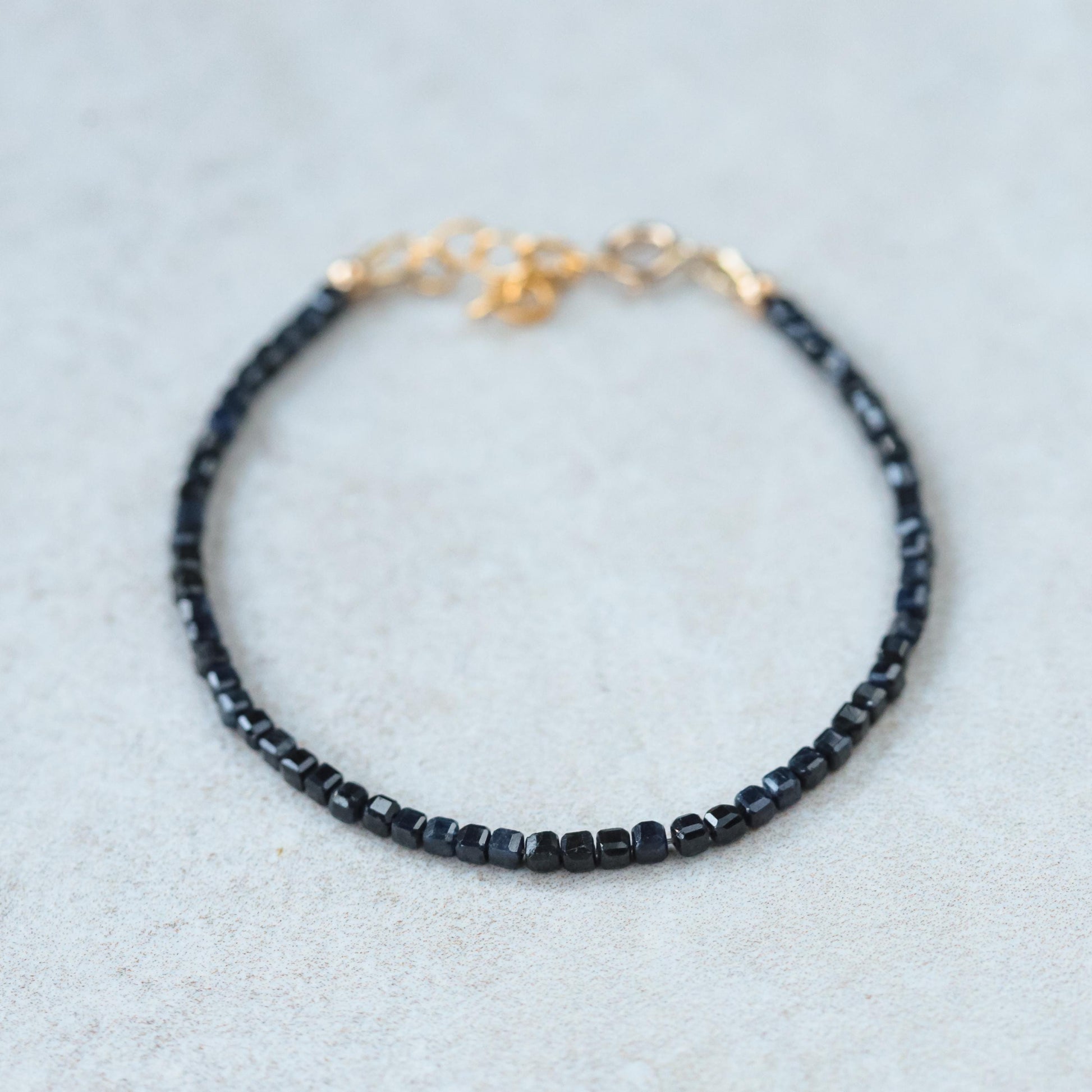 Cube-cut gemstone bracelet featuring 14K gold setting from Earthly Abundance, showcasing vibrant, polished gemstones on a delicate chain.