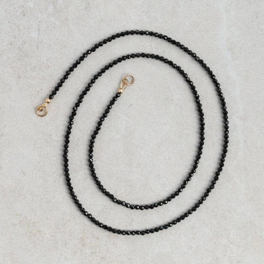 Lore Black Tourmaline necklace with 14K gold chain, featuring a polished black tourmaline pendant, from Earthly Abundance.