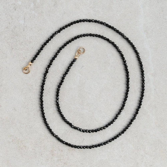 Lore Black Tourmaline Necklace with 14K gold chain from Earthly Abundance, showcasing a polished black tourmaline pendant.