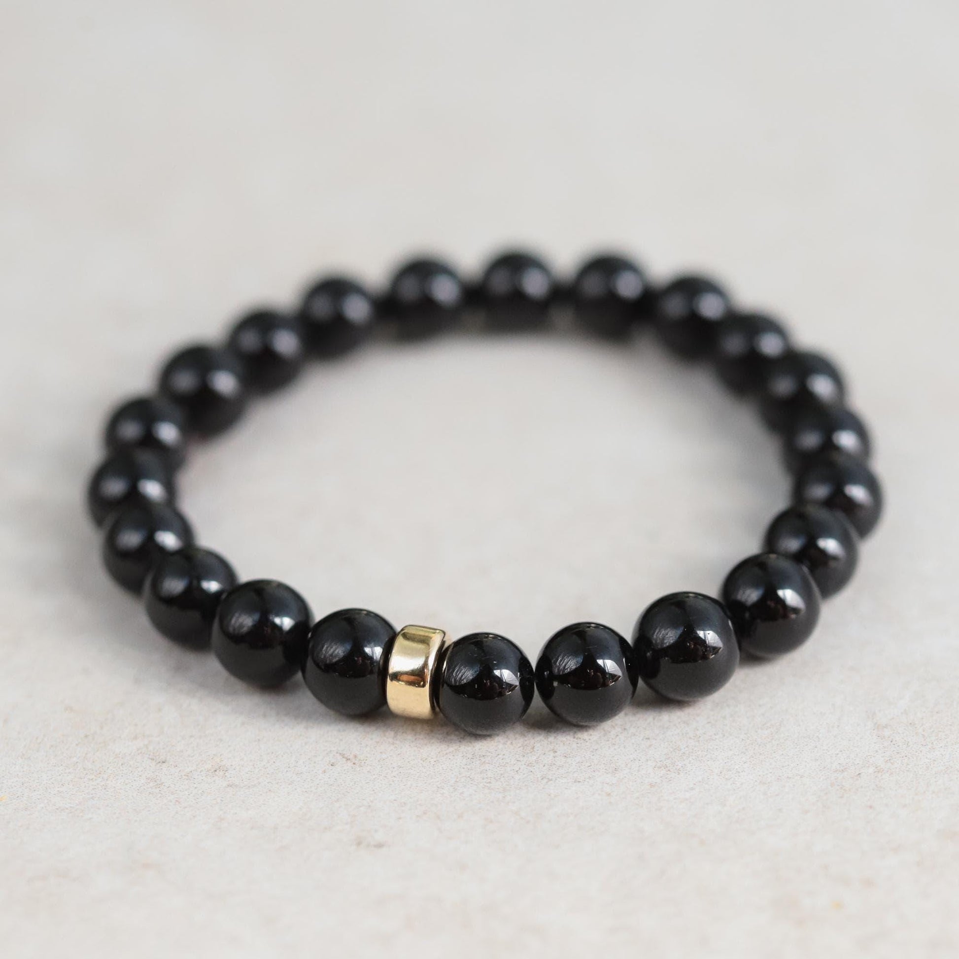 Black Tourmaline bracelet from Earthly Abundance Jewelry featuring protective, polished black stones on a stretch band.