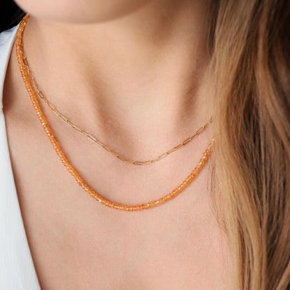 Orange sapphire necklace in 14K gold with a vibrant orange sapphire pendant, elegant jewelry piece by Earthly Abundance.