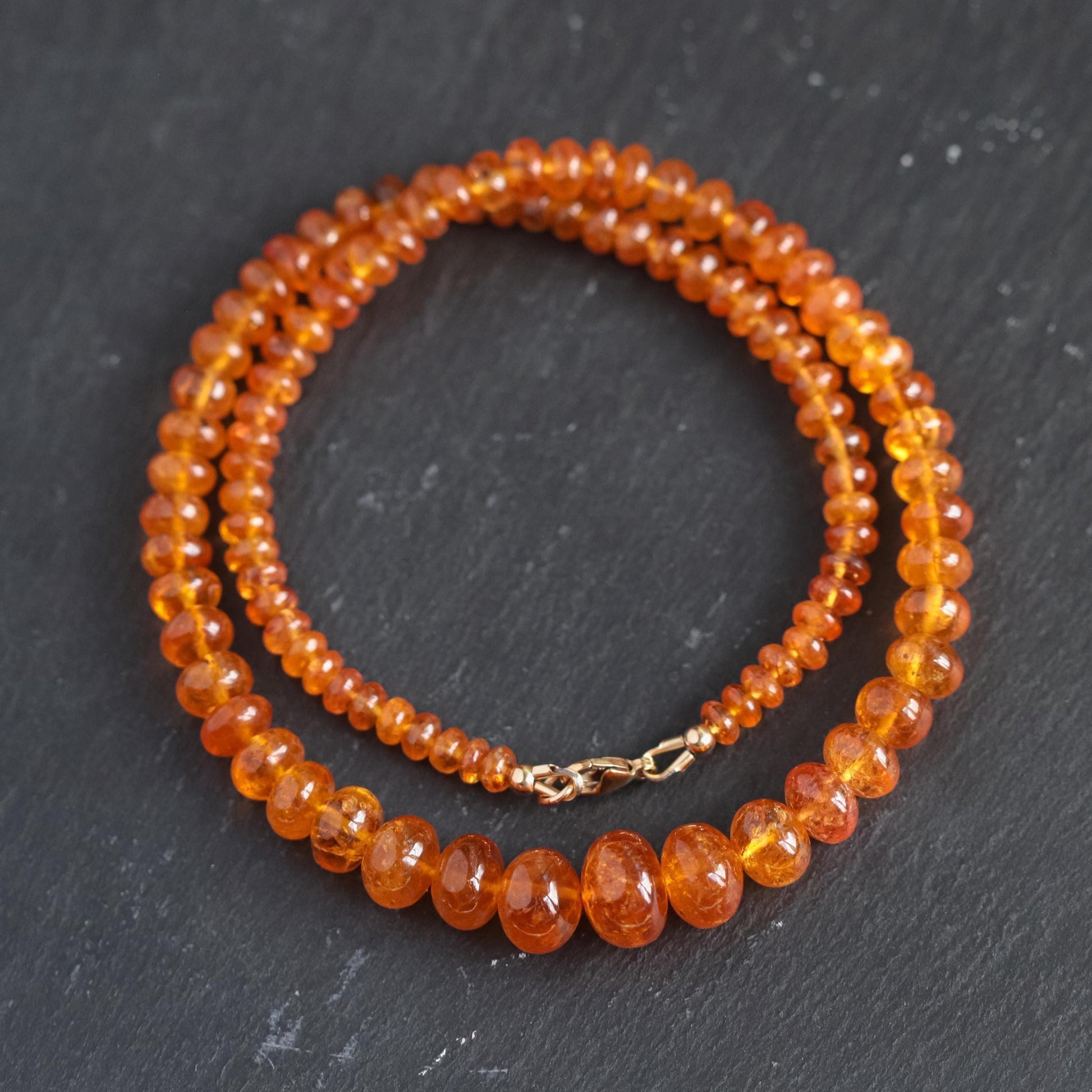 Spessartite garnet necklace with 14K gold setting, featuring a vibrant orange-red gemstone on a delicate gold chain.
