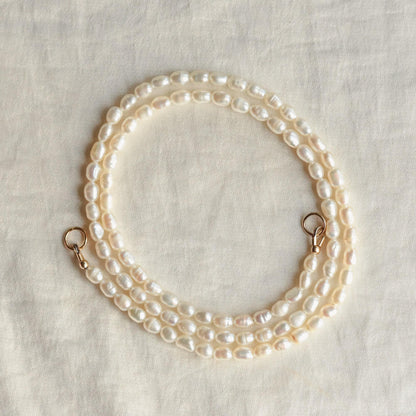 Elegant Solstice Pearl Necklace by Earthly Abundance featuring lustrous white pearls on a delicate chain.