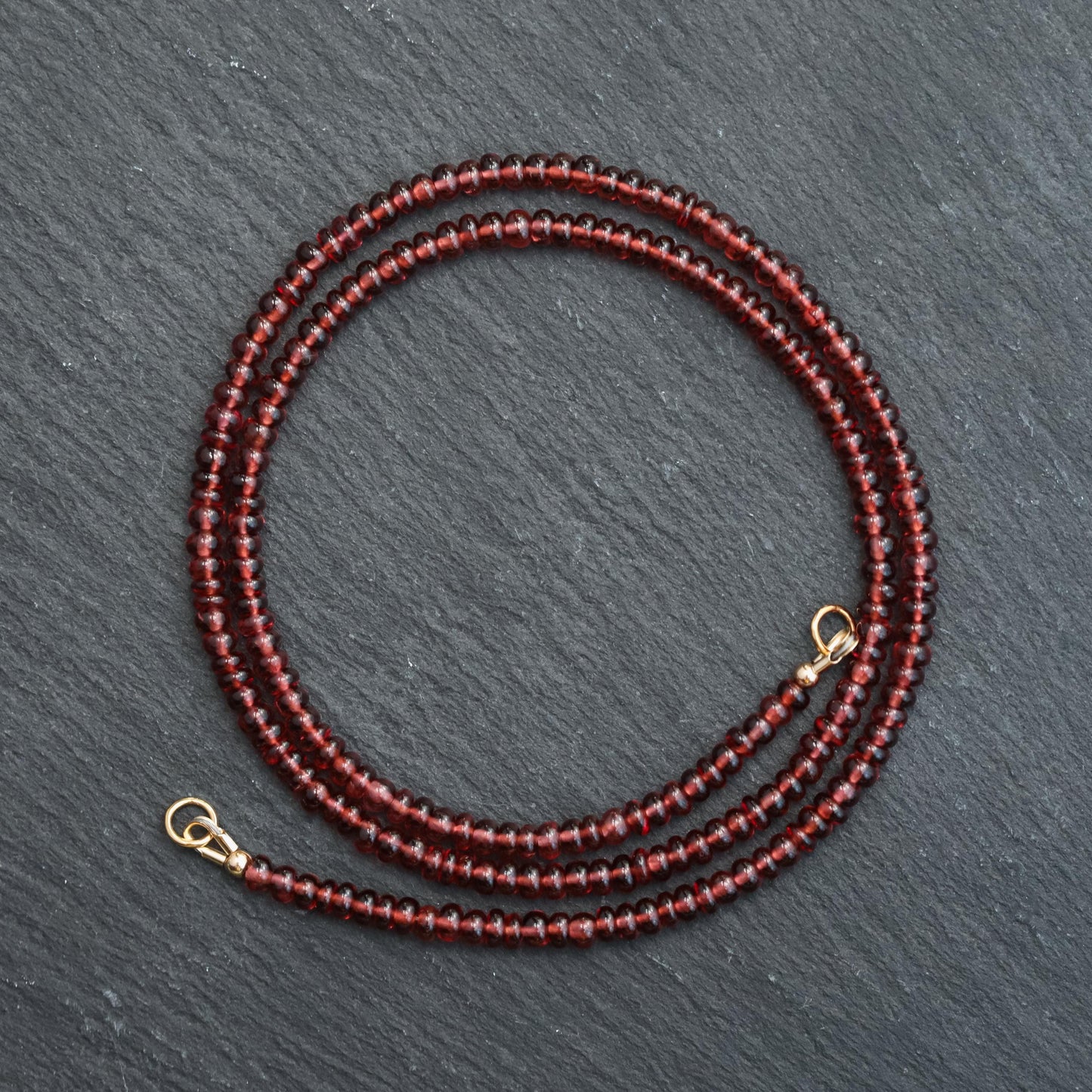 Garnet Carabiner Necklace by Earthly Abundance featuring a polished garnet gemstone attached to a metal carabiner clip.