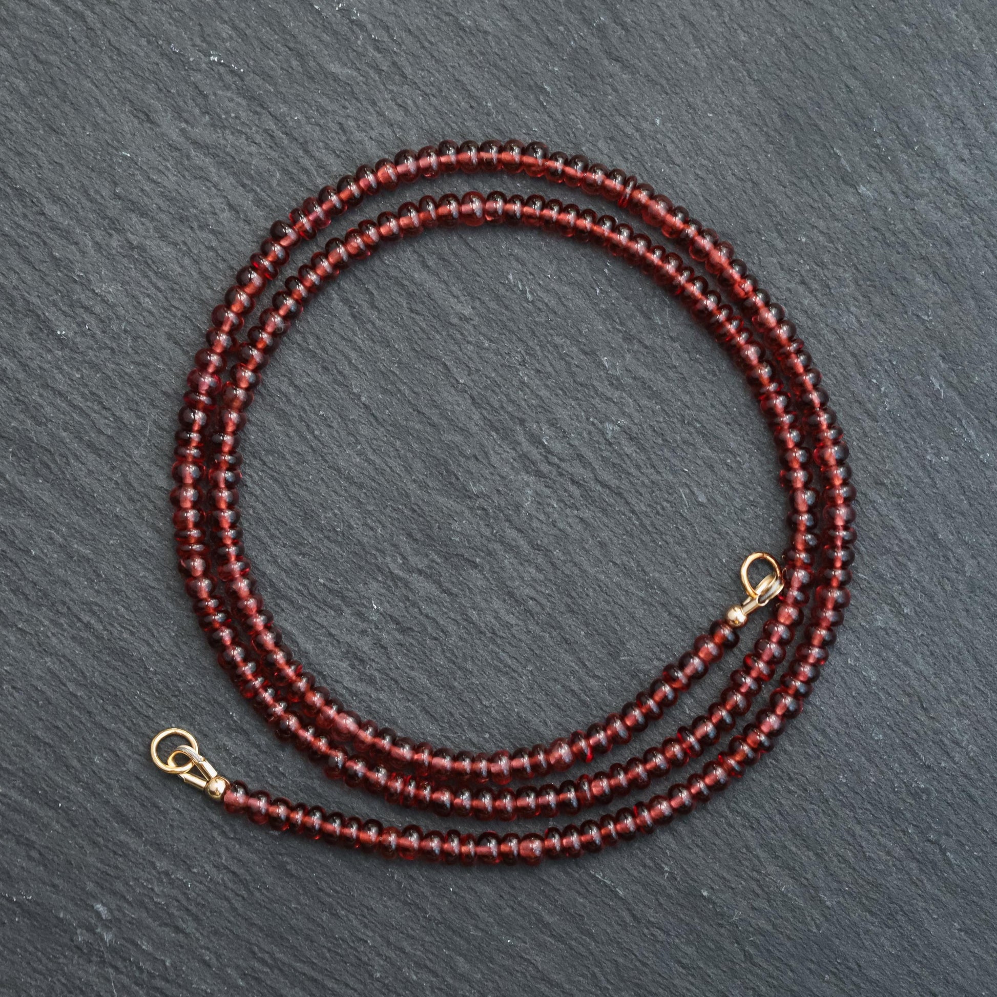 Garnet Carabiner Necklace by Earthly Abundance featuring a polished garnet gemstone attached to a metal carabiner clip.