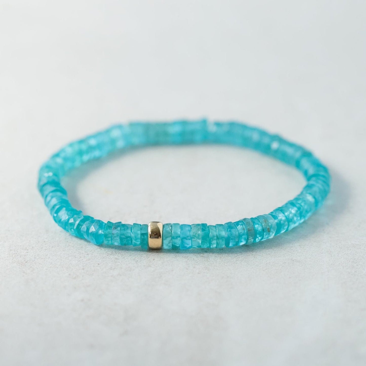 Earthly Abundance Apatite Heishi bracelet with small blue-green gemstone beads and elastic stretch band.