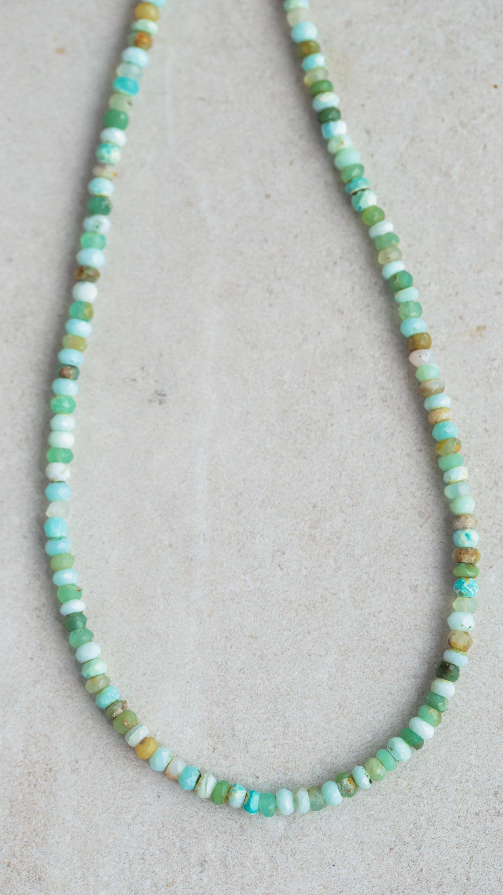 Peruvian opal necklace featuring vibrant, polished stones on a delicate chain, styled for elegant wear.