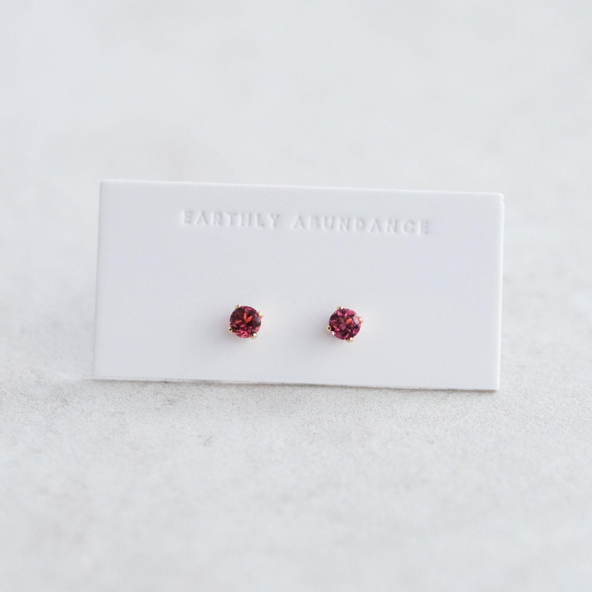 Pink tourmaline stud earring by Earthly Abundance featuring a sparkling pink gemstone set in a silver or gold stud.