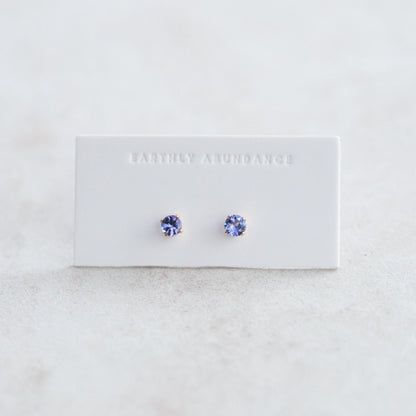 Pair of Tanzanite stud earrings with silver settings, showcasing vibrant blue-purple gemstones on a white background.