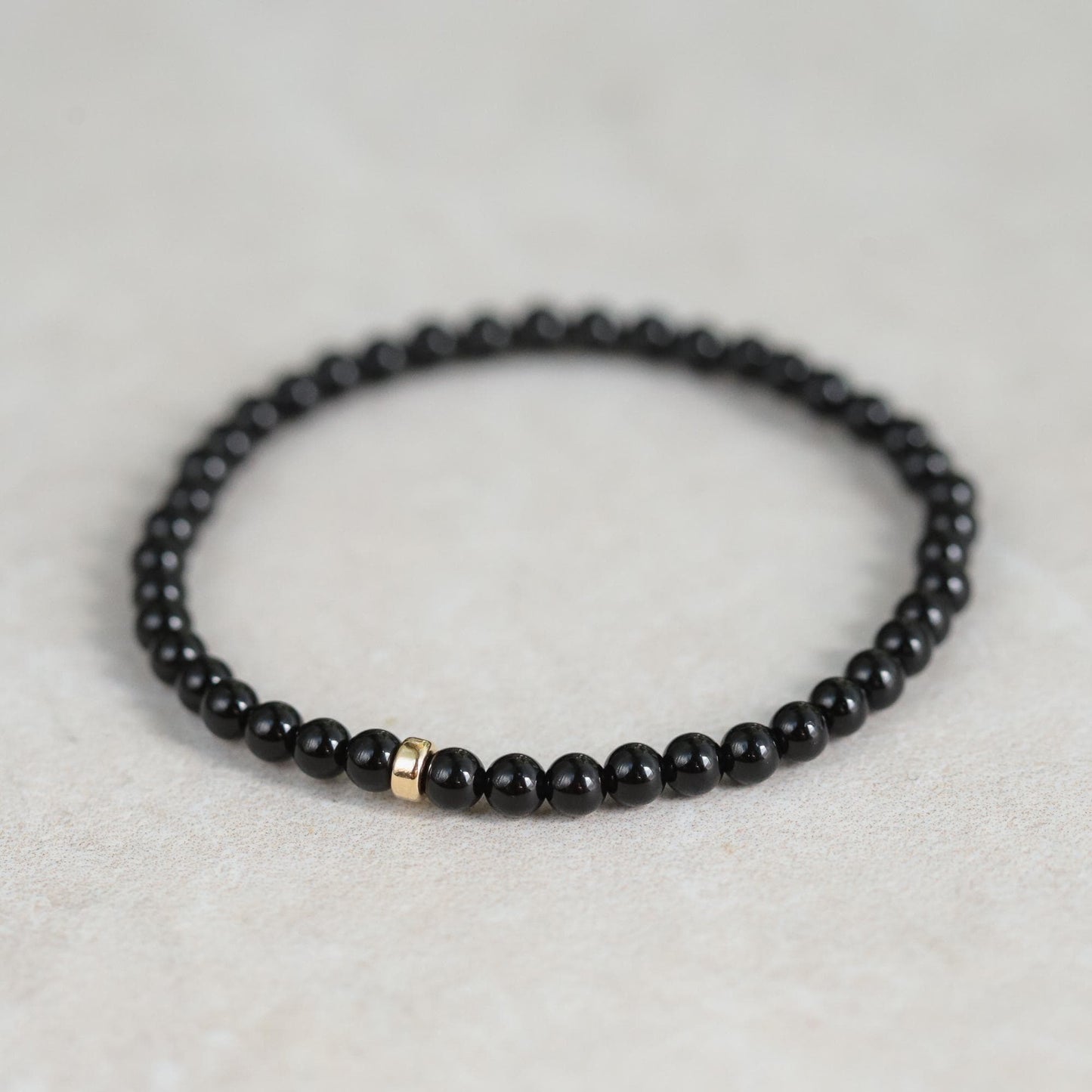 Black Tourmaline bracelet from Earthly Abundance Jewelry featuring protective black gemstones, styled on a person's wrist.