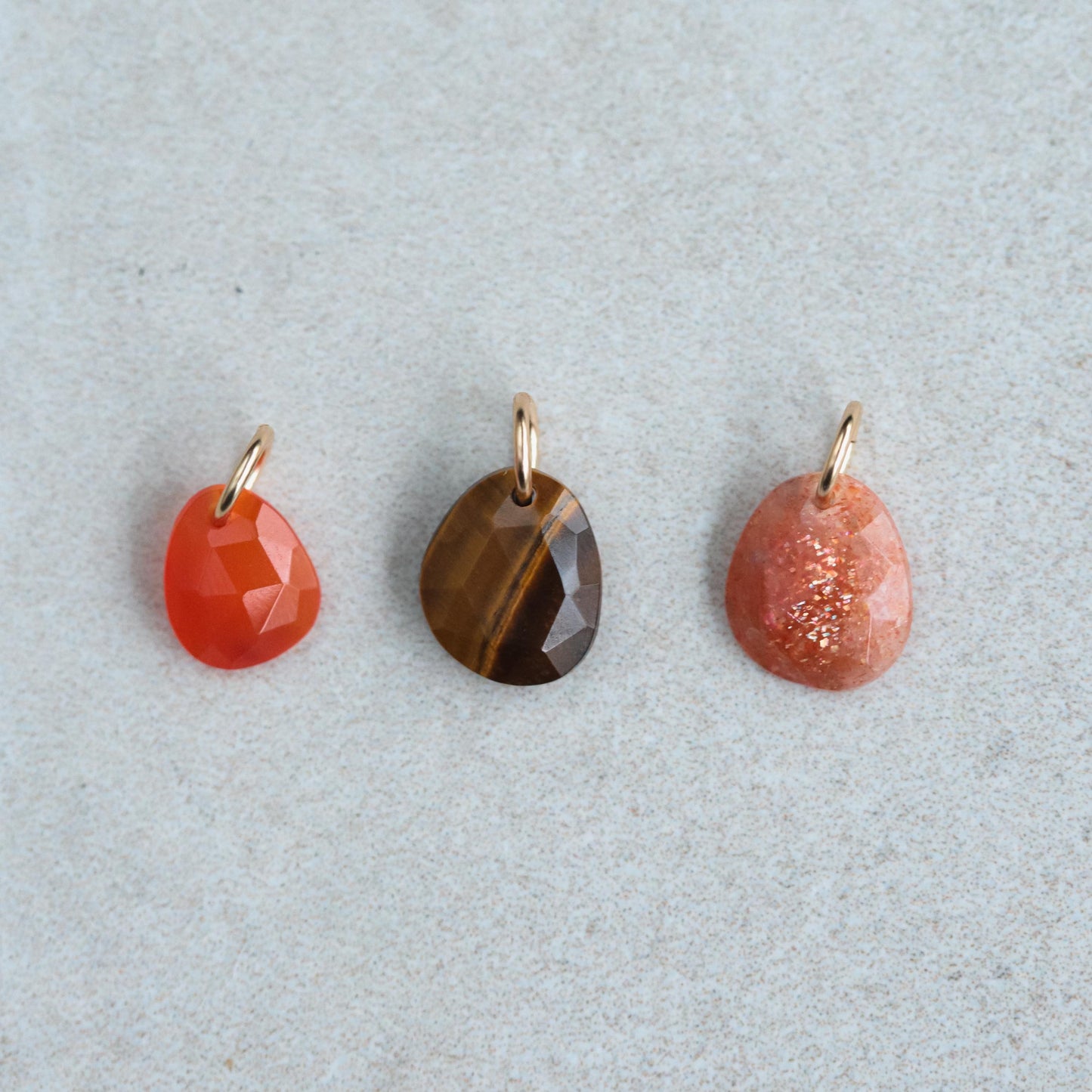 Sunstone pendant necklace in 14K gold with a polished sunstone gemstone, featuring a delicate chain on a neutral background.
