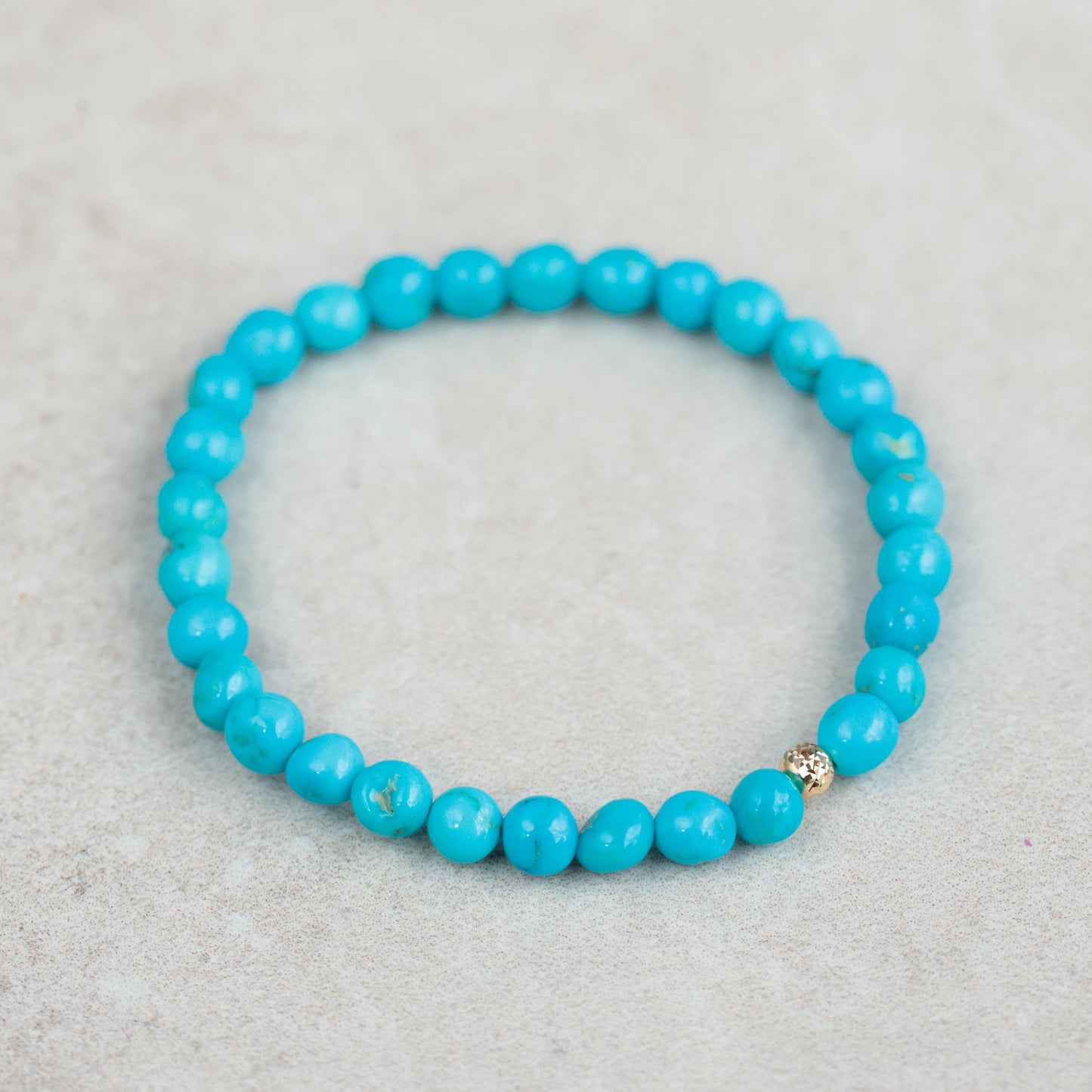 Earthly Abundance Jewelry Sleeping Beauty everyday bracelet featuring turquoise-colored beads and a delicate charm design.