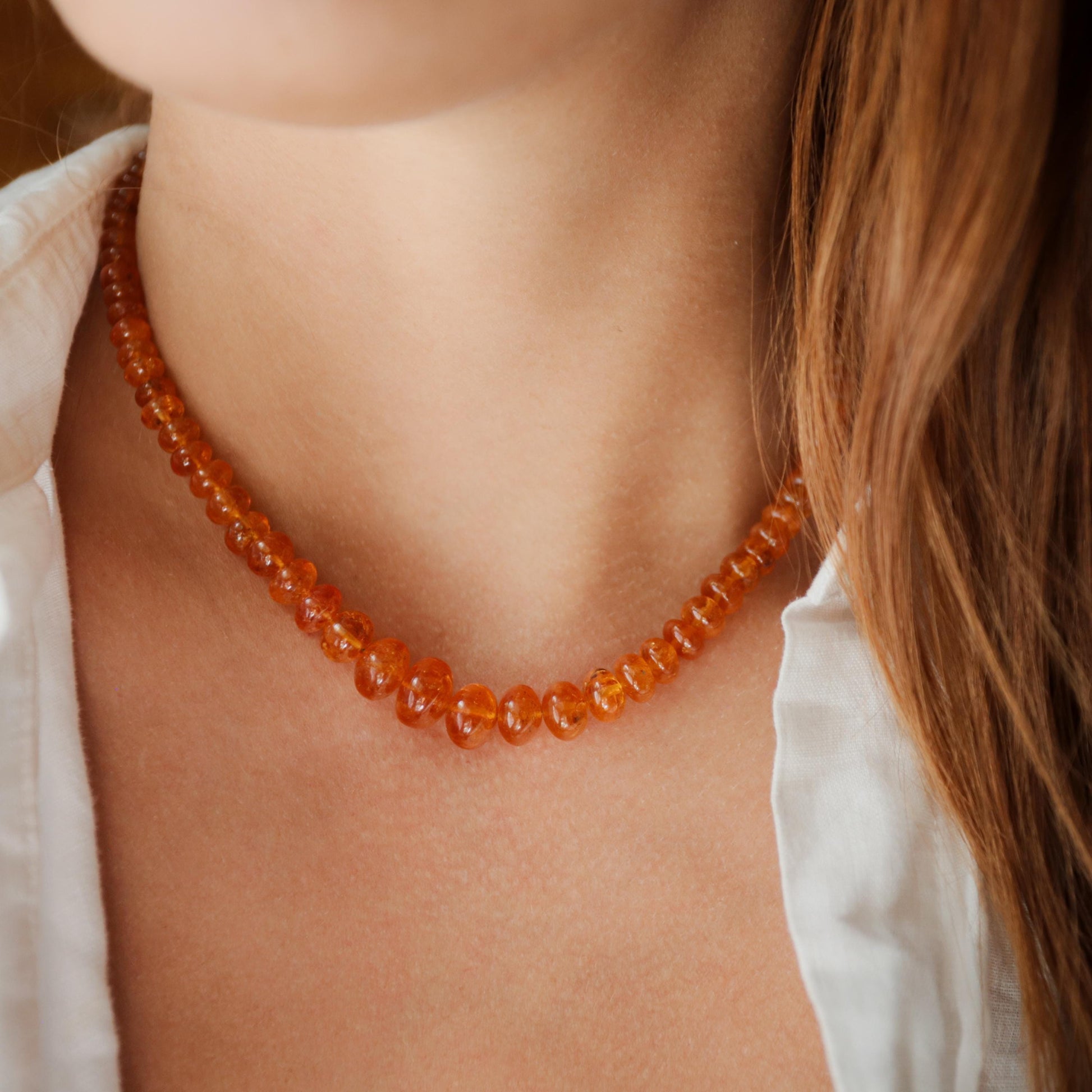 Spessartite Garnet necklace with 14K gold chain from Earthly Abundance, featuring a vibrant orange gemstone pendant.