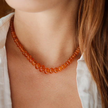 Spessartite Garnet necklace with 14K gold chain from Earthly Abundance, featuring a vibrant orange gemstone pendant.