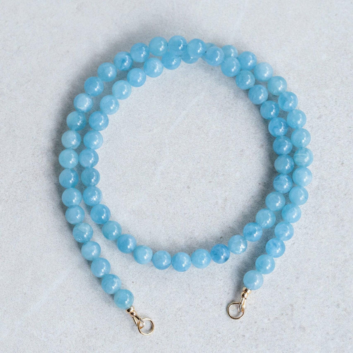 Aquamarine carabiner necklace by Earthly Abundance featuring a silver-toned metal clasp and a polished aquamarine gemstone.