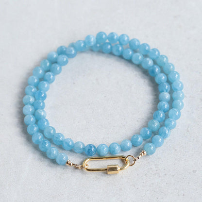 Aquamarine Carabiner Necklace by Earthly Abundance featuring a silver-tone metal carabiner and a vibrant aquamarine gemstone pendant.