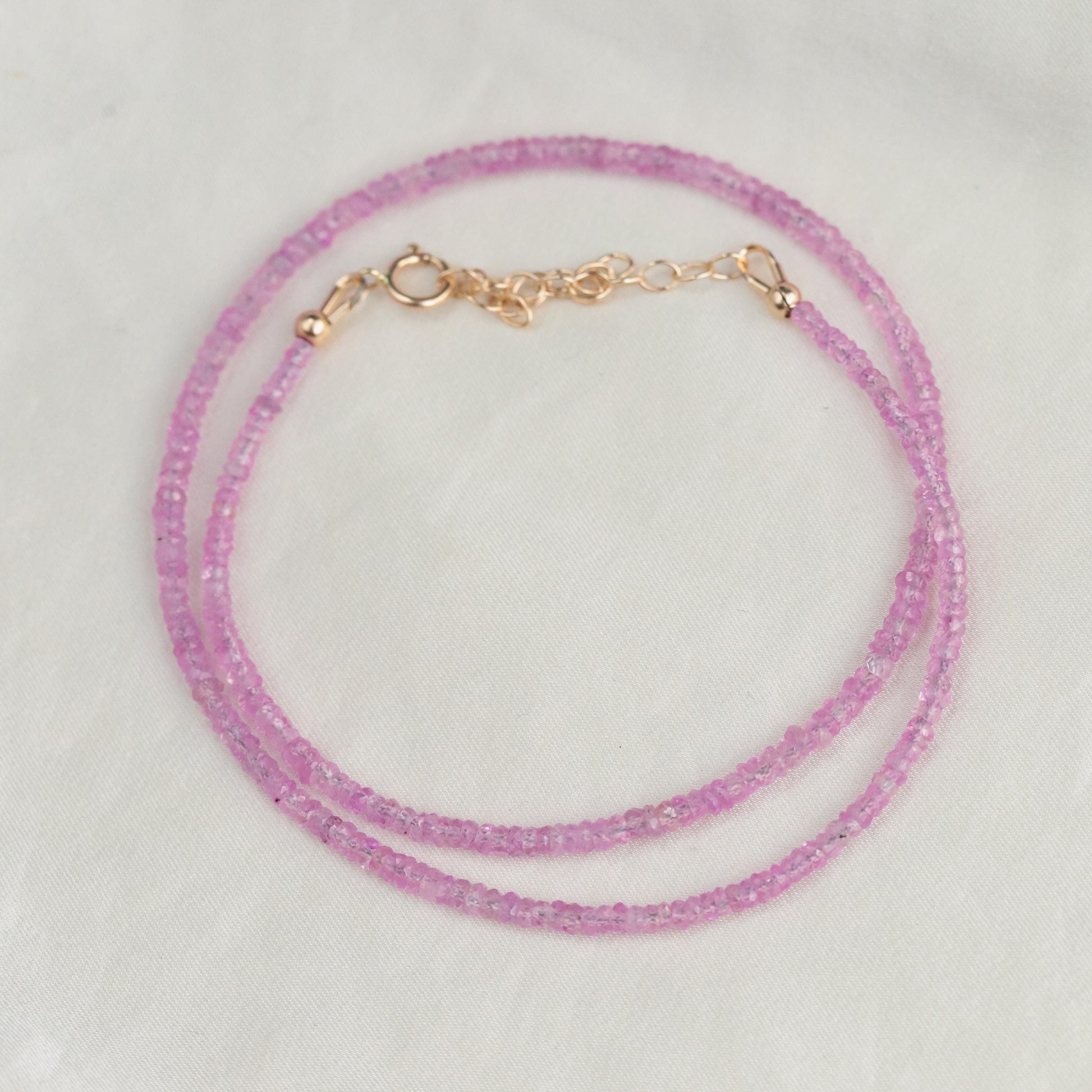 Pink sapphire necklace from Earthly Abundance featuring a string of vibrant pink sapphires on a delicate chain.