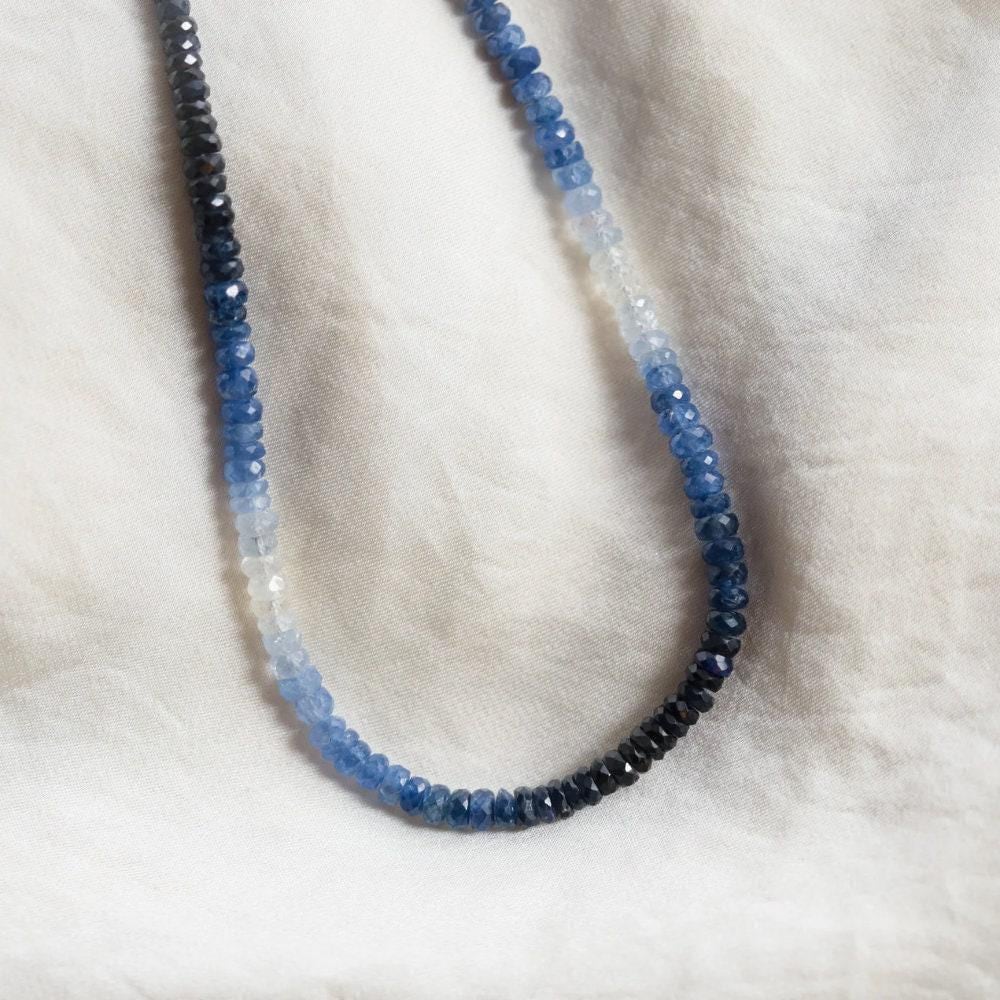 Indigo to sky blue sapphire necklace from Earthly Abundance Jewelry with a delicate silver chain and gradient gemstone pendant.